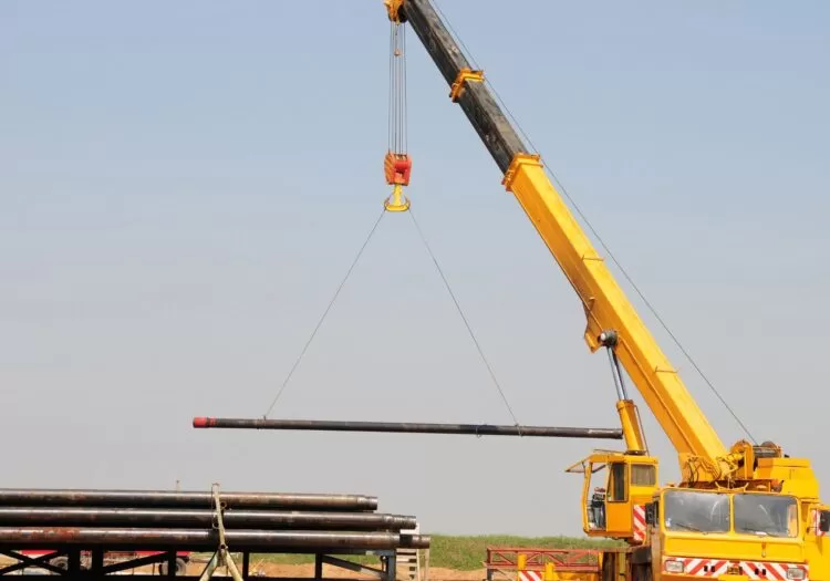 o que é içamento: Veiculo com uma ponta alta para carregar materiais suspensos.