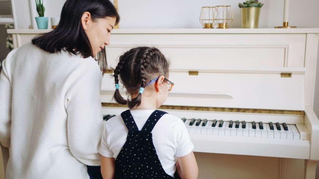 Içamento de Piano: mulher e criança tocando piano.