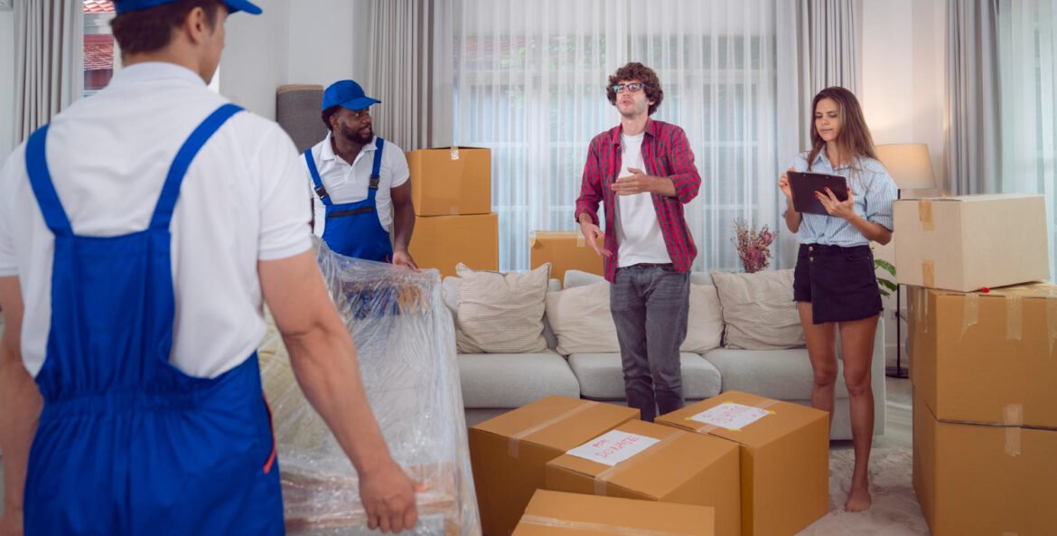 XJ6 mudanças vs Içamentos Força Máxima: Homens de empresa de mudança conversando com casal.